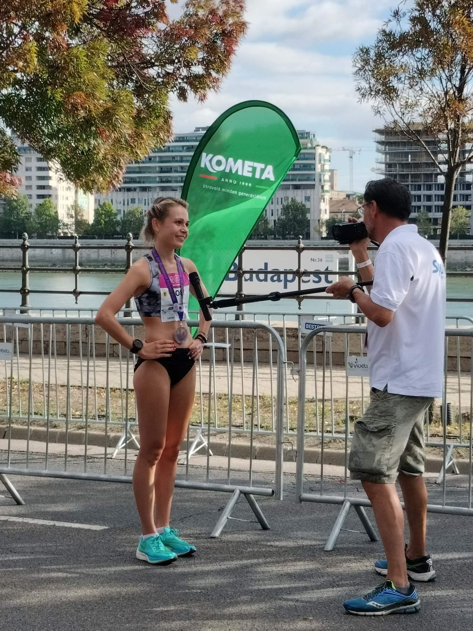 Julianna Nagy interjút ad a Kometa zászló előtt, Budapest